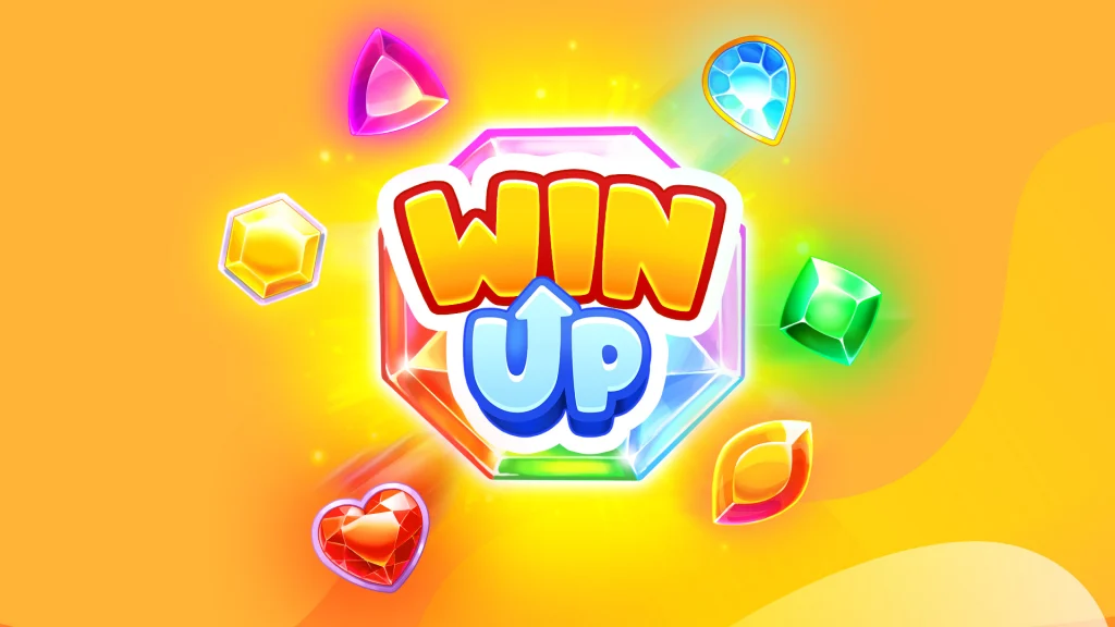 With a gold background, colored gems glimmer and float around a big rainbow gem in the middle and the words “Win Up” in yellow and blue just on top of it.
